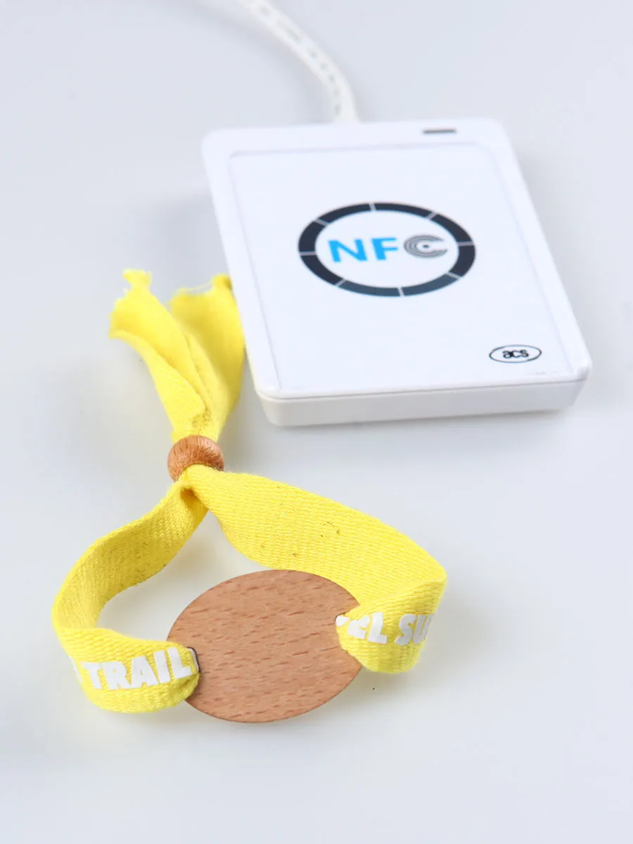 Guest tapping an RFID event wristband on a handheld reader at a gate